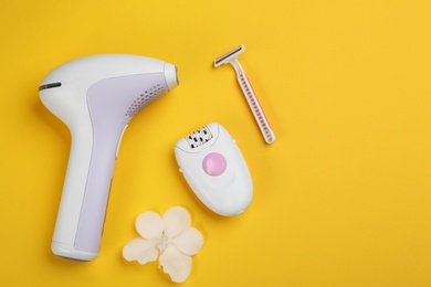 Image of Modern devices for epilation on yellow background, flat lay 