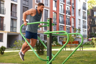 Man training on parallel bars at outdoor gym
