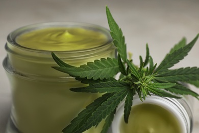 Jars of hemp cream on table, closeup. Organic cosmetics