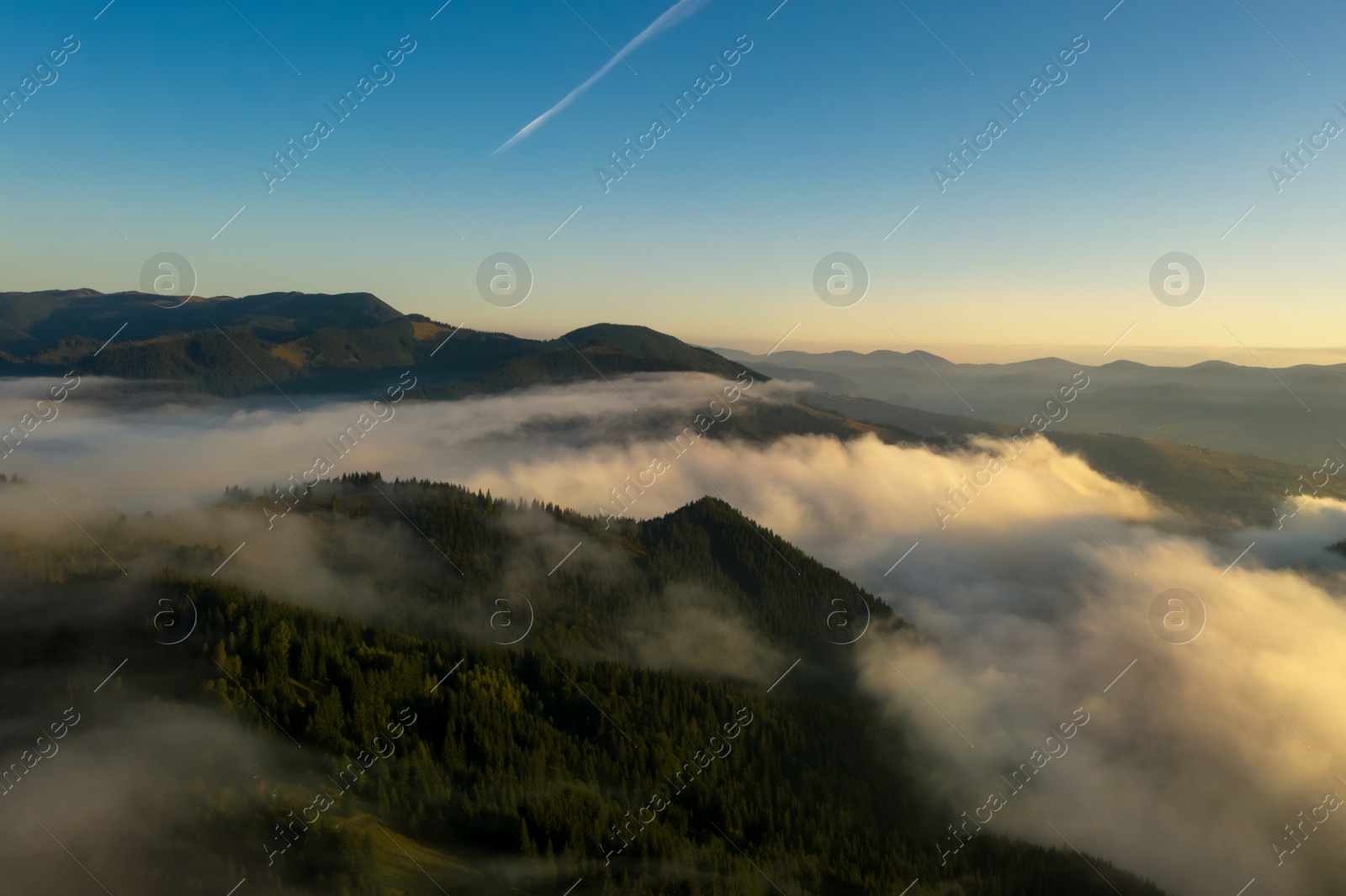 Image of Aerial view of beautiful mountains covered with fluffy clouds. Drone photography