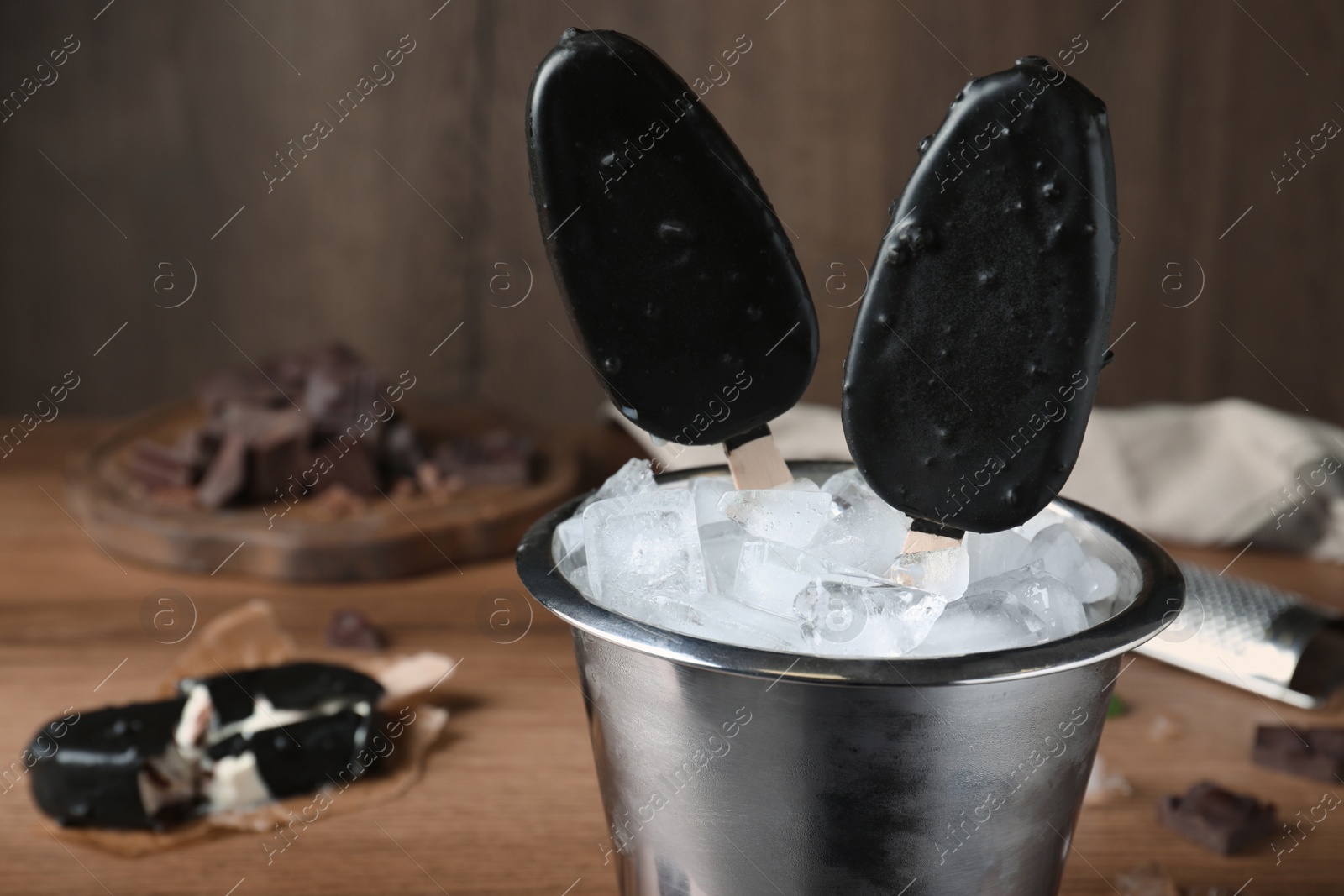 Photo of Glazed ice cream bars served in bucket on table. Space for text