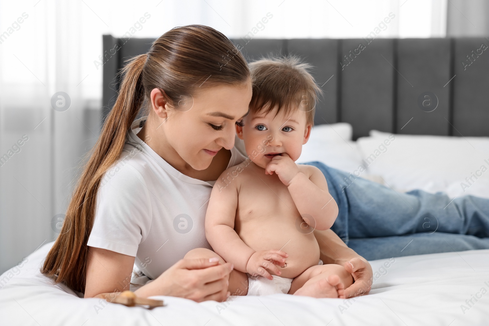 Photo of Mother with her baby on bed at home