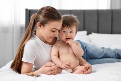 Photo of Mother with her baby on bed at home