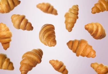 Image of Golden croissants falling on pink gradient background