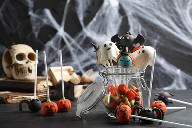 Different Halloween themed cake pops on black table