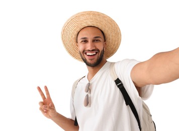Photo of Smiling young man in straw hat taking selfie and showing peace sign on white background