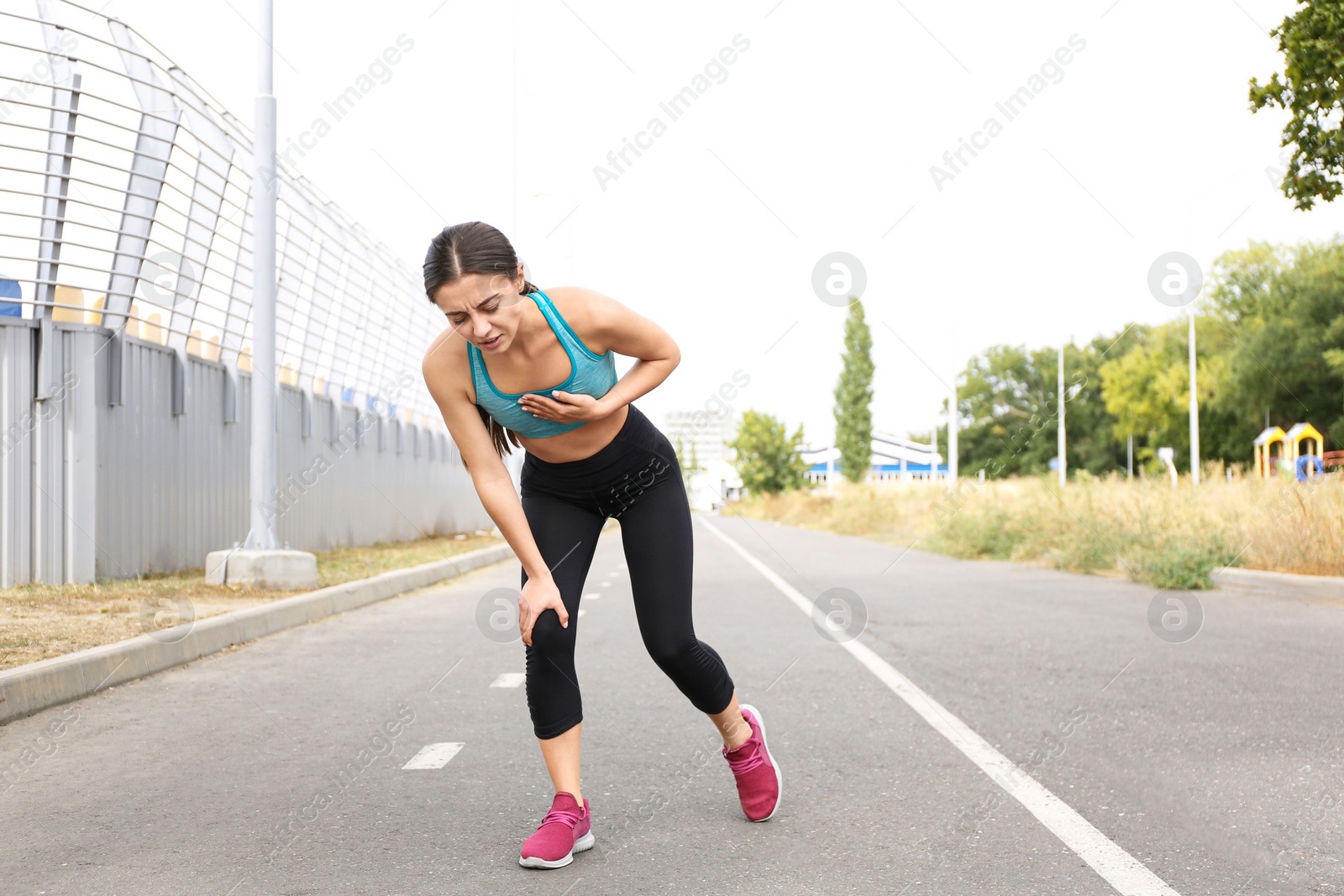 Photo of Young woman having heart attack while running outdoors