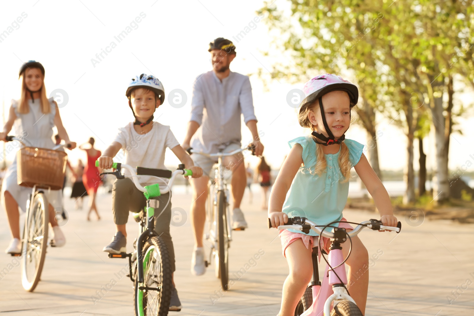 Photo of Happy family riding bicycles outdoors on summer day