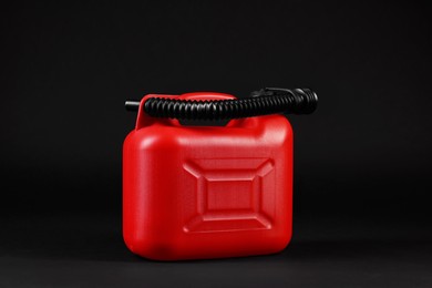 New red plastic canister on black background
