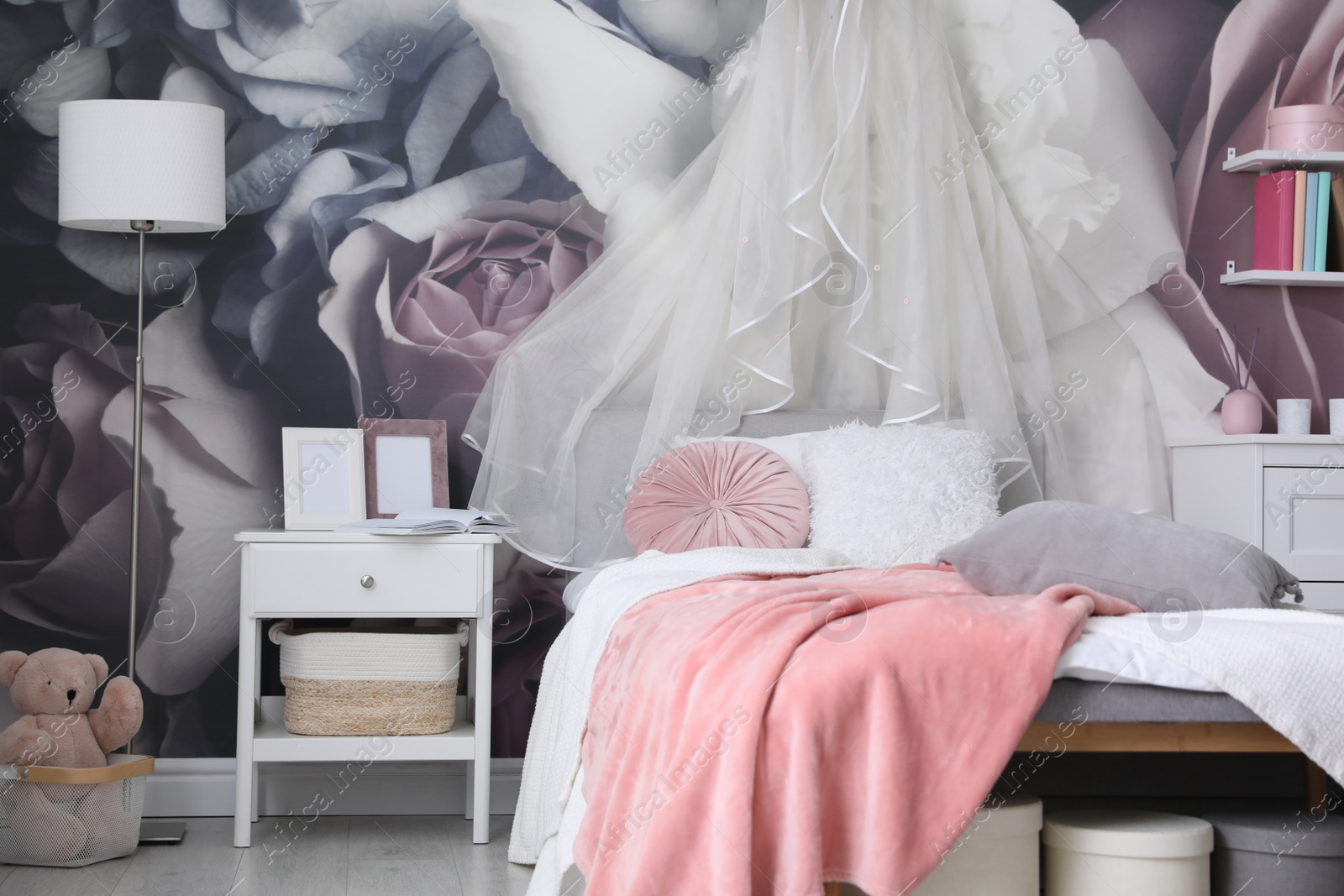 Photo of Teenage girl's room interior with comfortable bed and floral wallpaper. Idea for stylish design