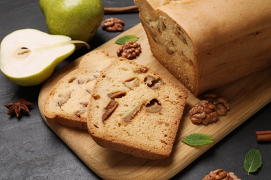 Photo of Tasty cut pear bread on black table, closeup. Homemade cake