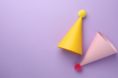 Photo of Beautiful party hats on purple background, top view. Space for text