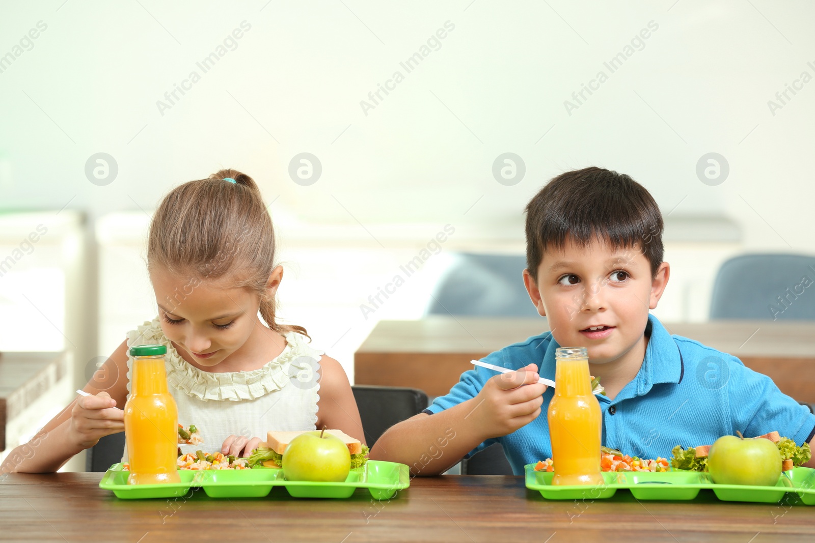 Photo of Happy children eating healthy food for lunch in school canteen