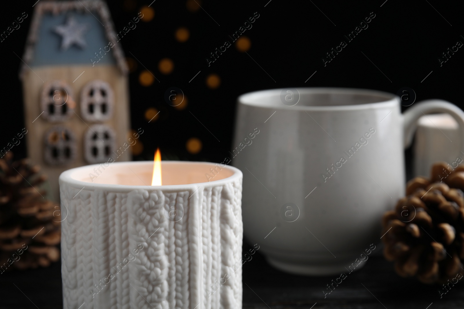 Photo of Composition with candle in ornate holder on table. Christmas decoration