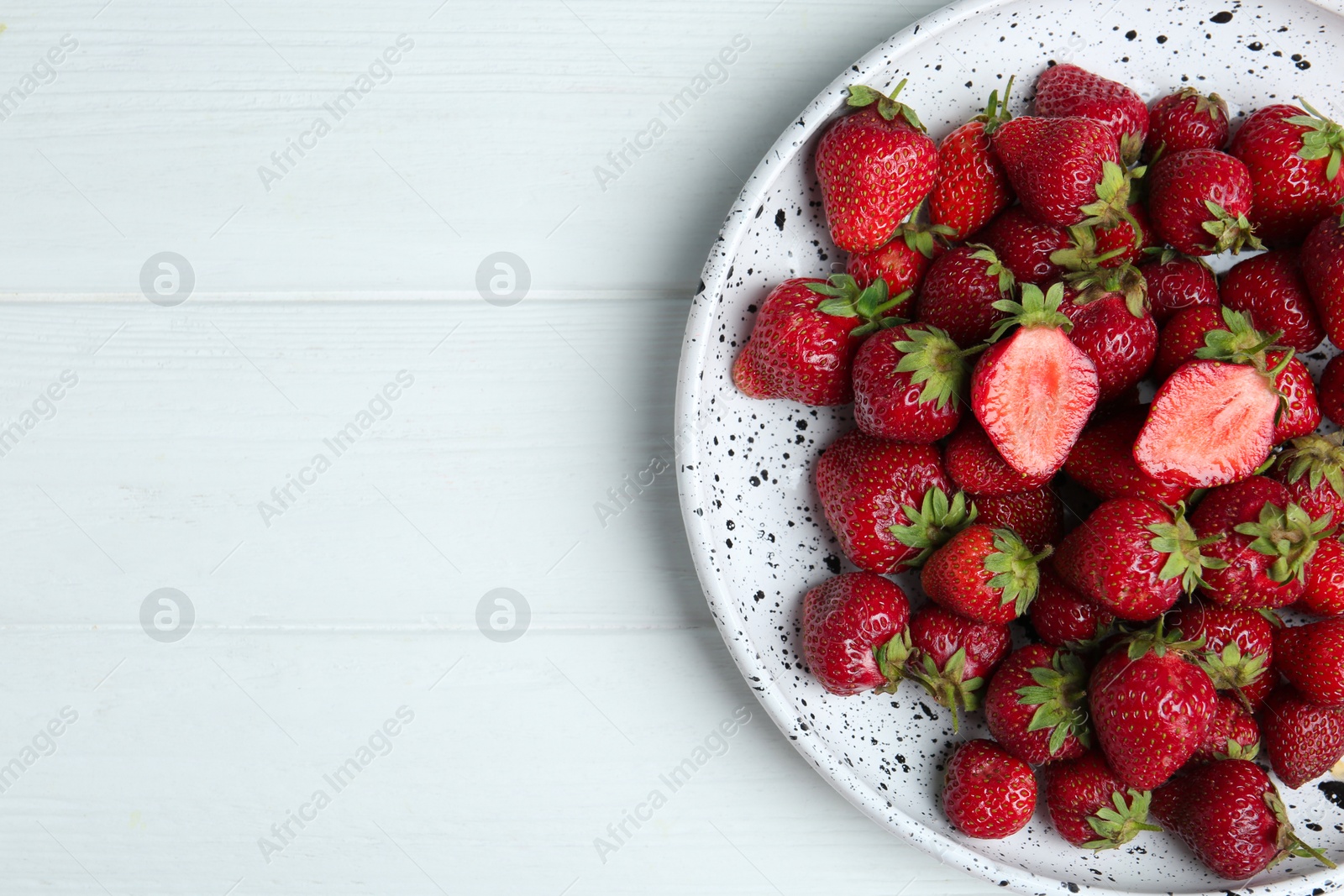 Photo of Delicious ripe strawberries on white wooden table, top view. Space for text