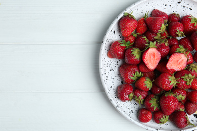 Photo of Delicious ripe strawberries on white wooden table, top view. Space for text