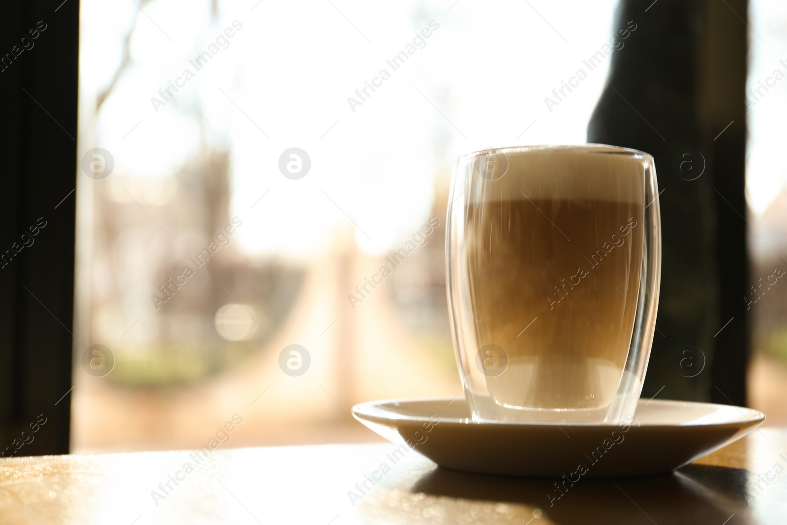 Photo of Glass of delicious latte on table in cafe. Space for text