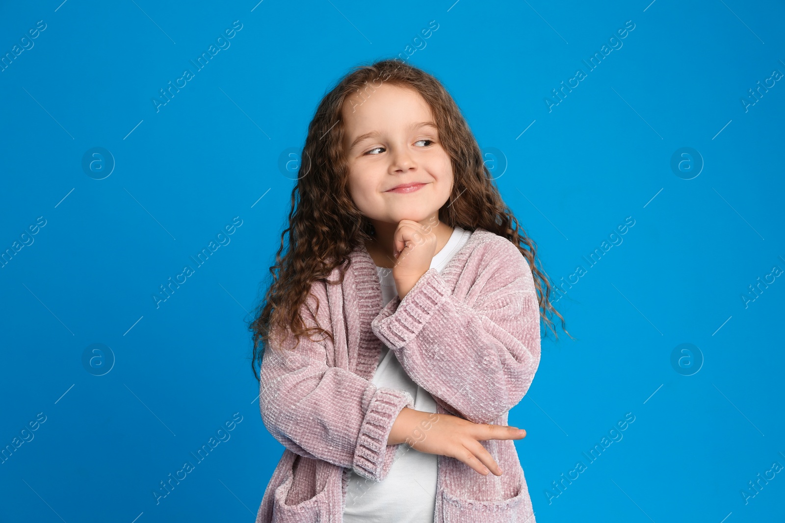 Photo of Portrait of cute little girl on light blue background