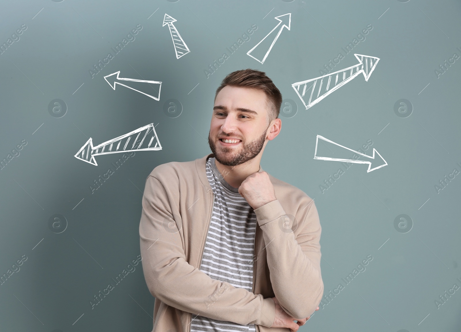 Image of Choice in profession or other areas of life, concept. Making decision, young man surrounded by drawn arrows on grey background