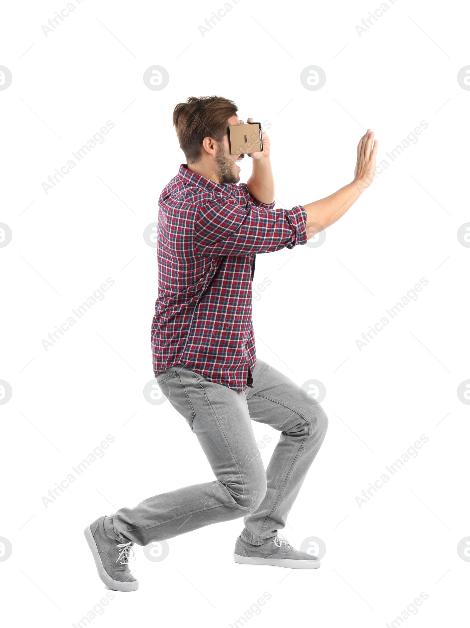 Photo of Young man using cardboard virtual reality headset, isolated on white