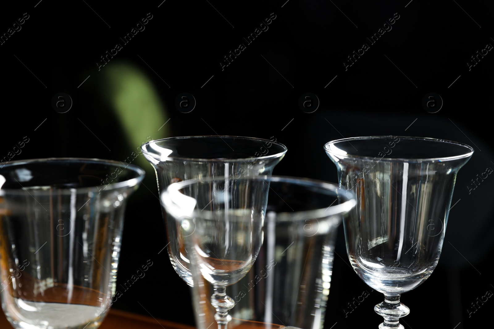 Photo of Empty clean glasses on dark background, closeup