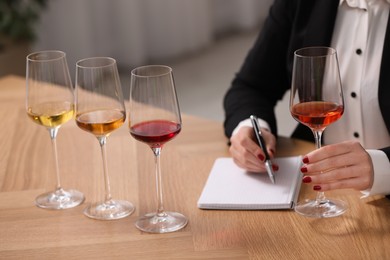 Photo of Sommelier tasting different sorts of wine at table indoors, closeup