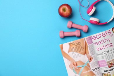 Flat lay composition with dumbbells on light blue background, space for text