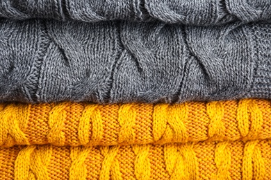 Grey and orange knitted plaids as background, closeup