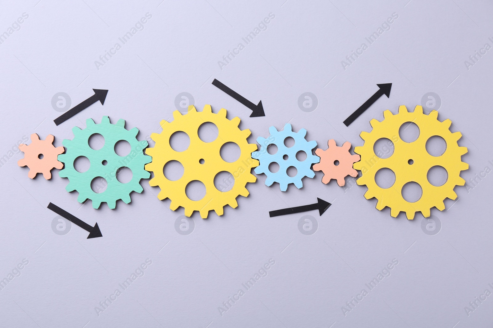 Photo of Business process organization and optimization. Scheme with wooden figures and arrows on lilac background, top view