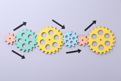 Photo of Business process organization and optimization. Scheme with wooden figures and arrows on lilac background, top view