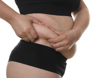 Woman touching belly fat on white background, closeup. Overweight problem