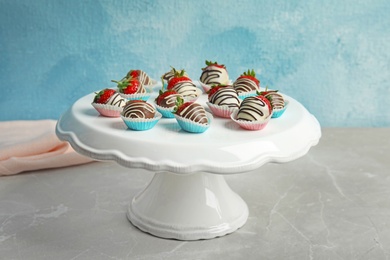 Photo of Dessert stand with chocolate covered strawberries on table