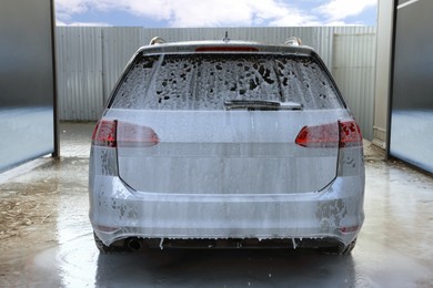 Auto with cleaning foam at outdoor car wash