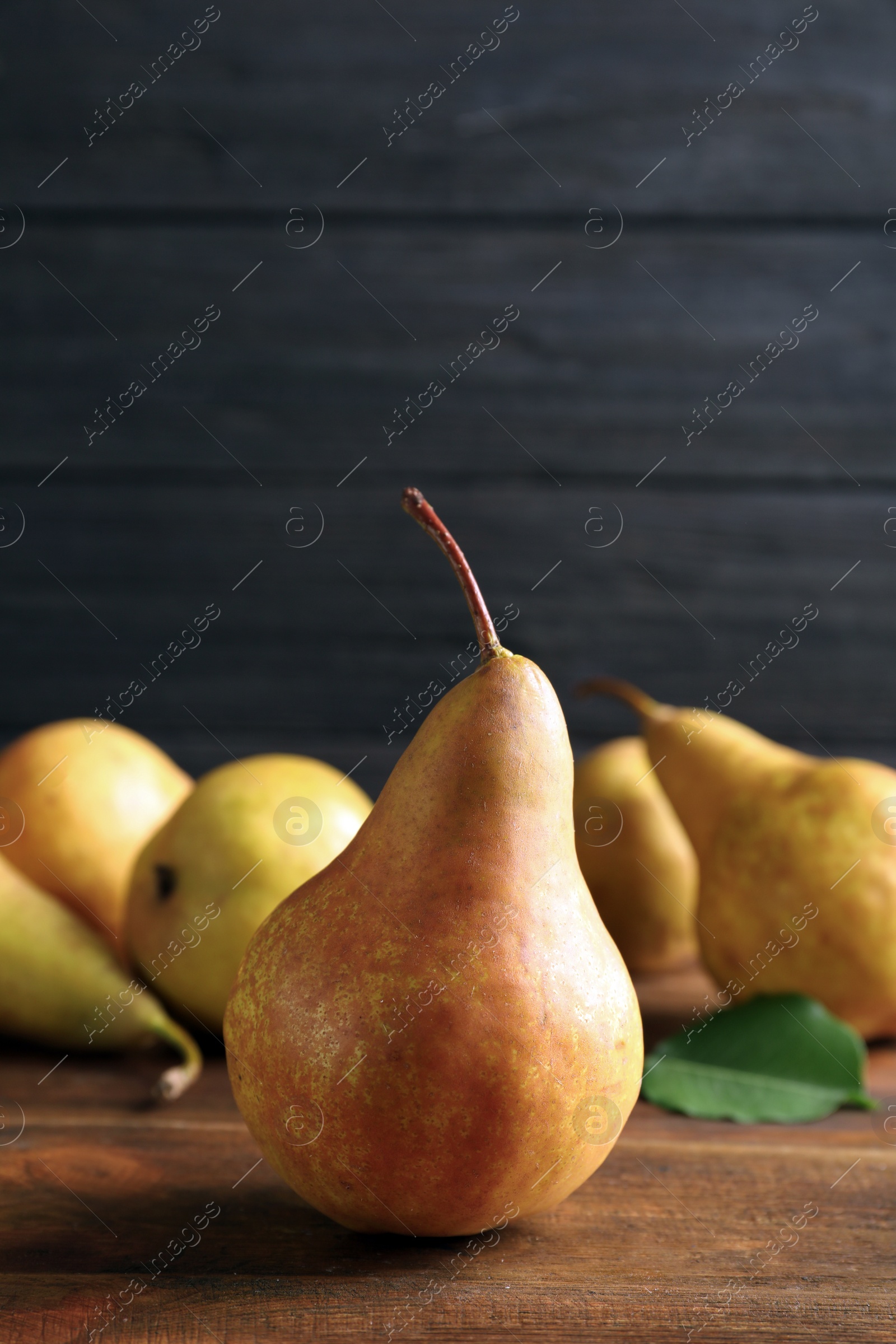 Photo of Ripe pear on wooden table. Space for text