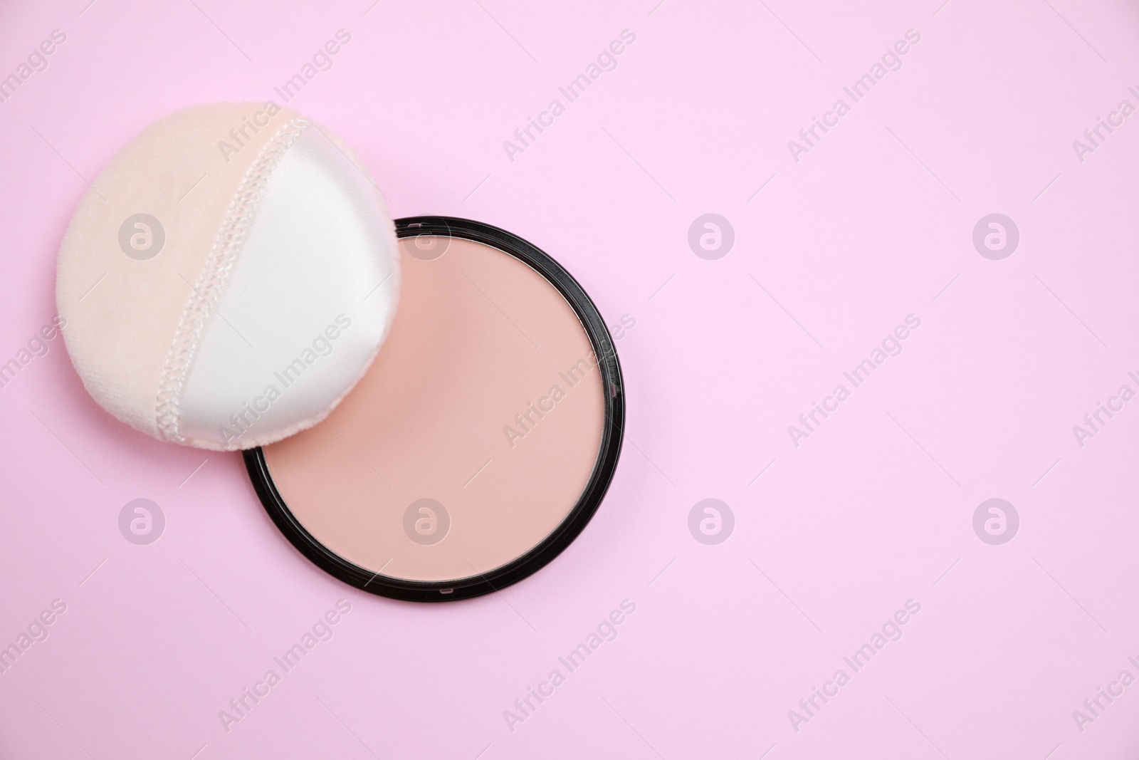 Photo of Face powder and puff on pink background, flat lay. Space for text