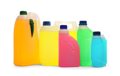 Plastic canisters with different liquids for car on white background