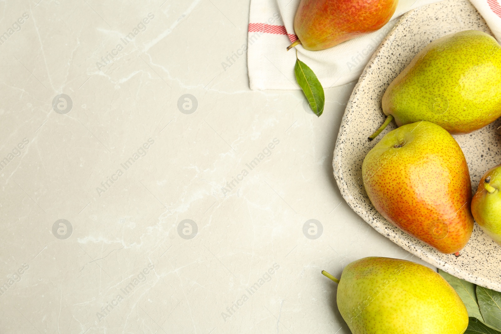 Photo of Plate with ripe juicy pears on light stone table, flat lay. Space for text