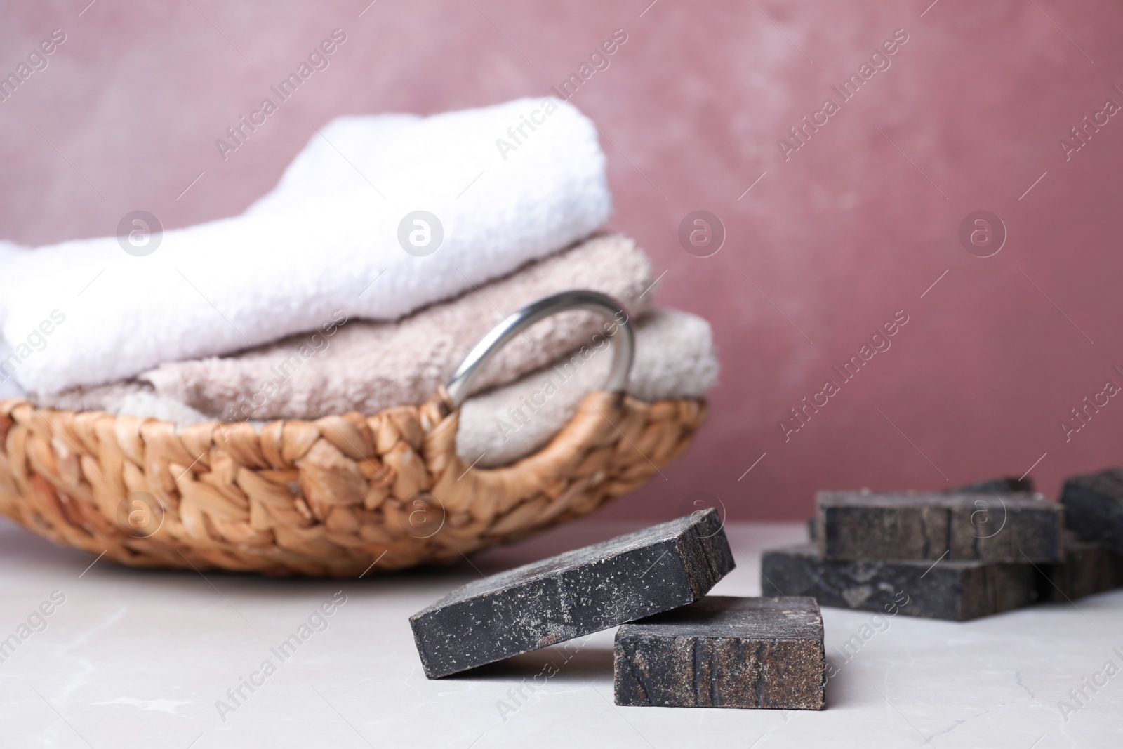 Photo of Natural handmade soap bars on light table against color background