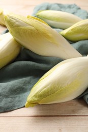 Photo of Raw ripe chicories on wooden table, closeup