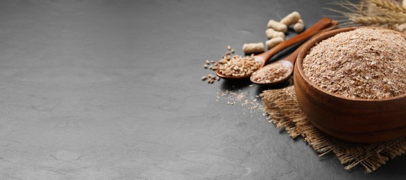 Wheat bran in bowl on black table. Space for text