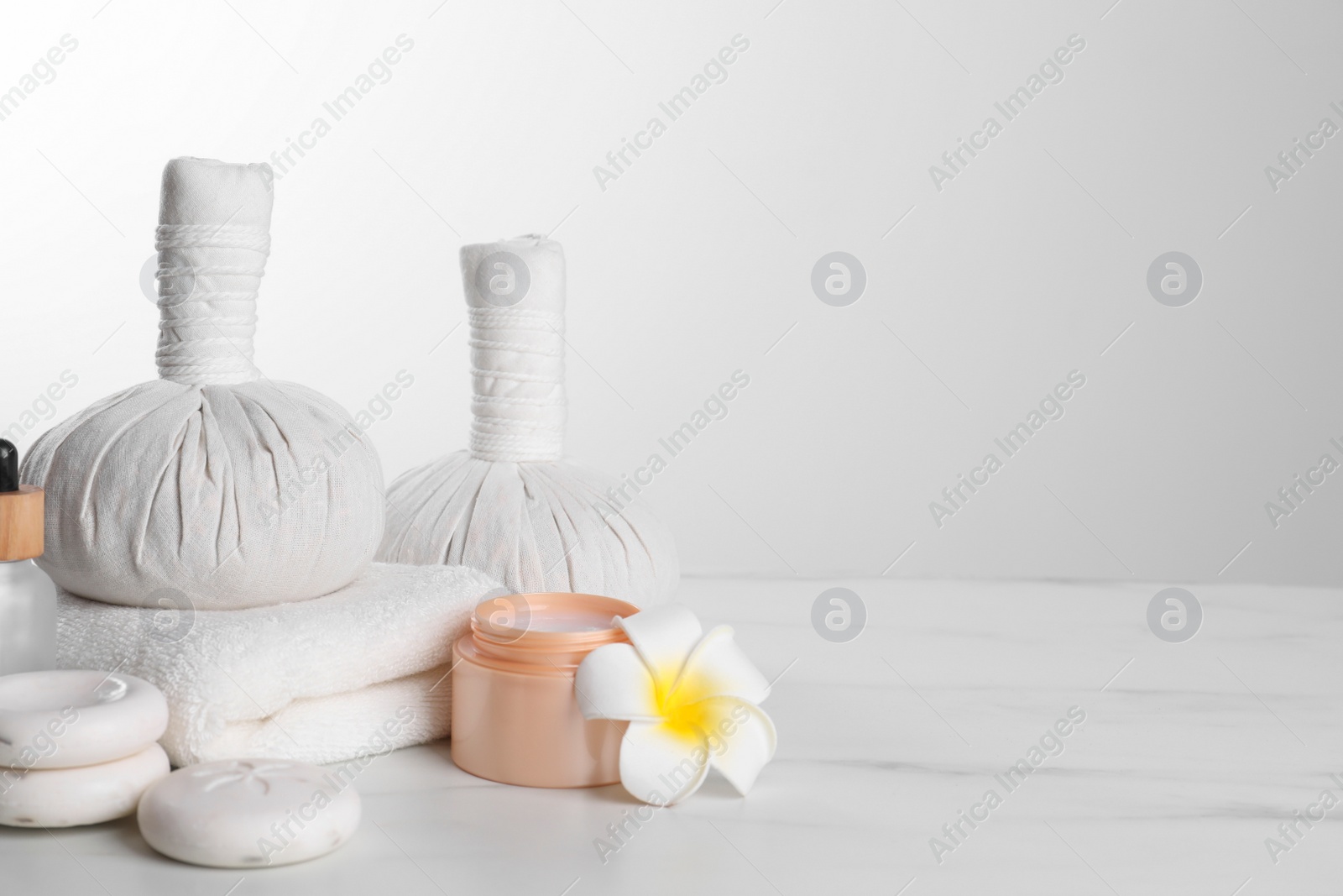 Photo of Spa composition with care products on white marble table. Space for text