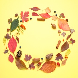 Frame made of autumn leaves on yellow background, top view. Space for text