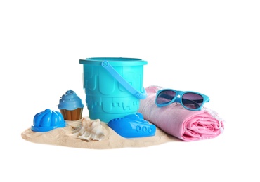 Photo of Set of plastic beach toys, blanket, sunglasses and pile of sand on white background