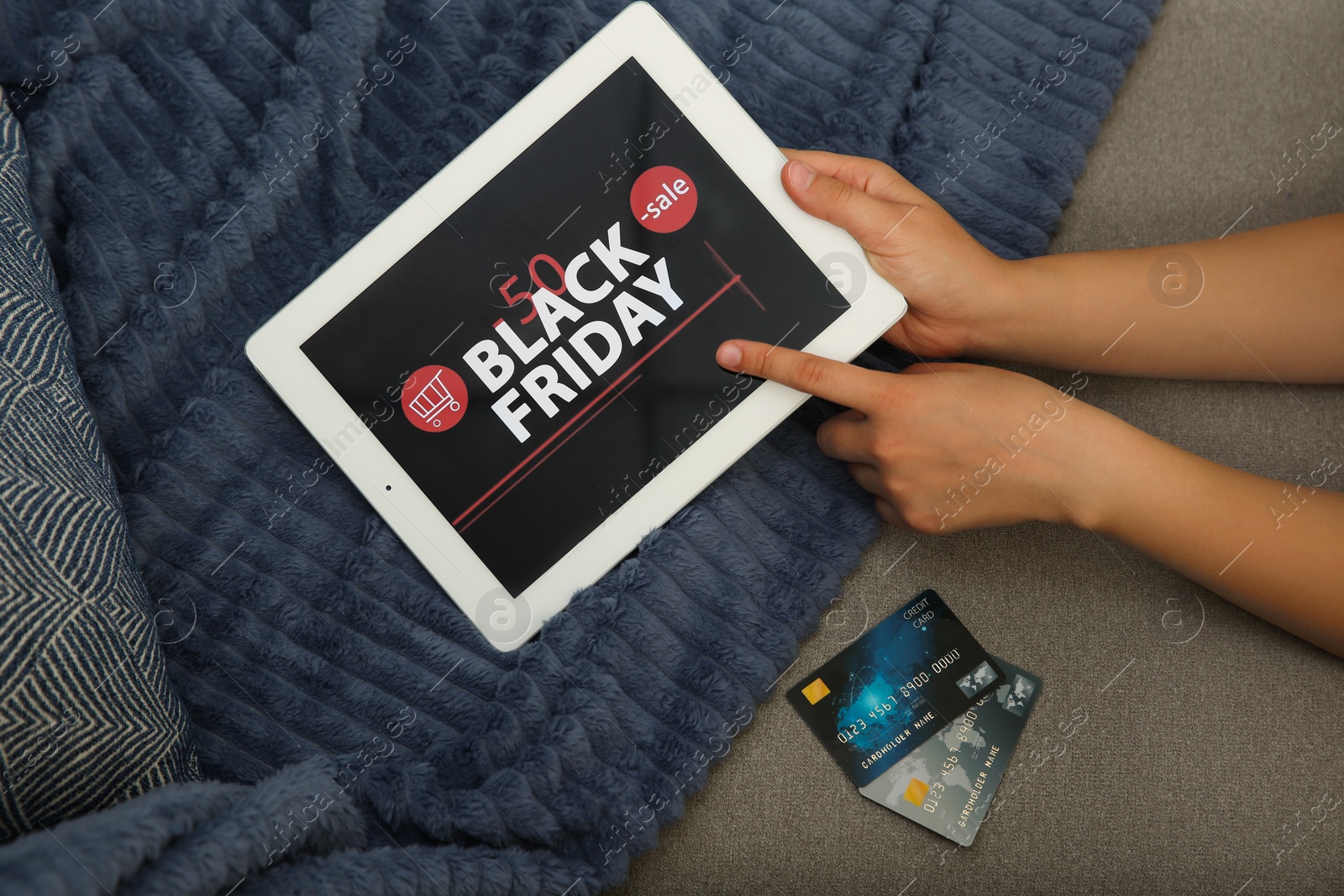 Photo of Woman with credit cards using tablet for online shopping on sofa, top view. Black Friday sale