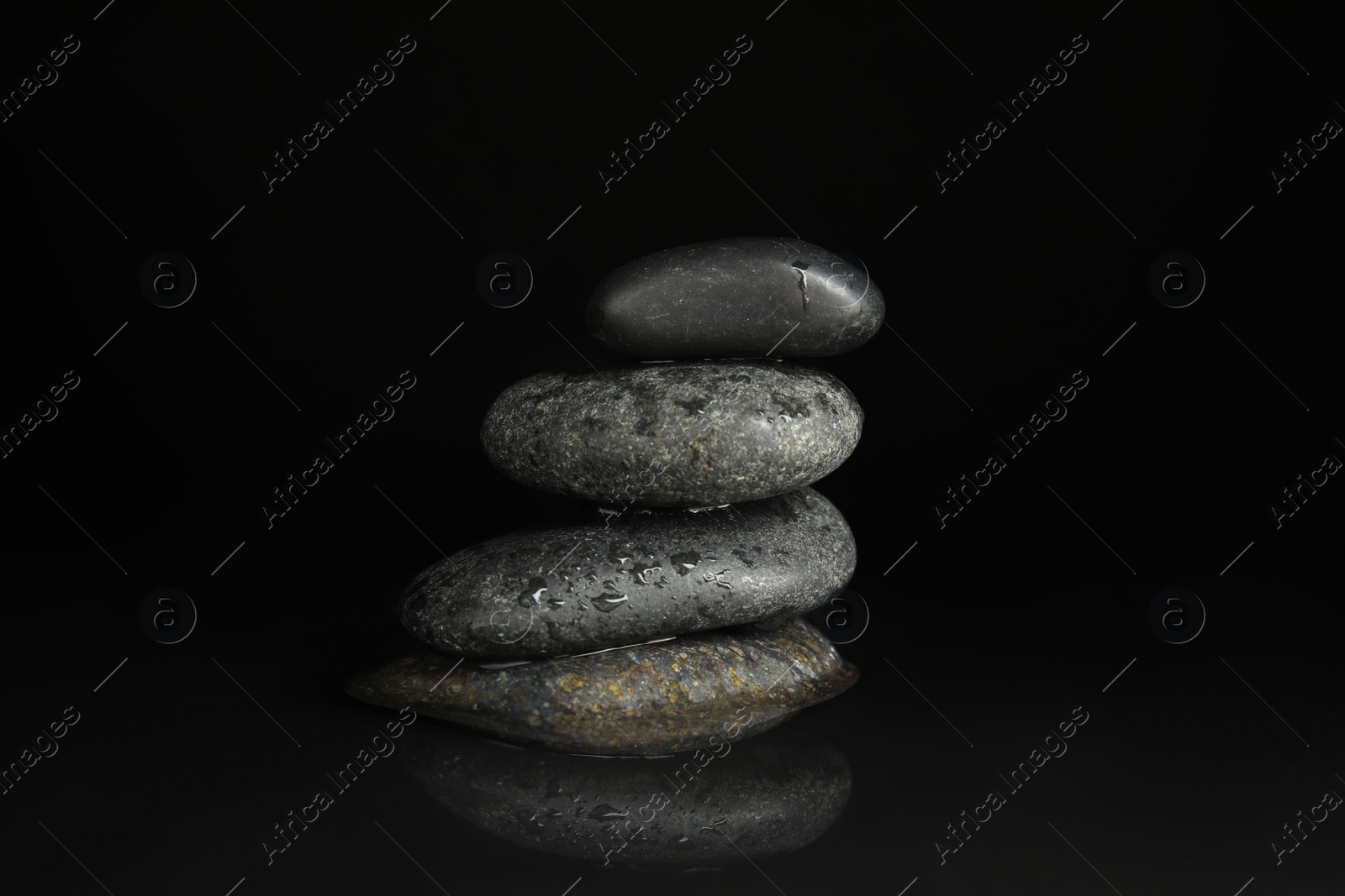 Photo of Stones in water on black background. Zen lifestyle