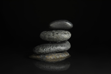 Photo of Stones in water on black background. Zen lifestyle