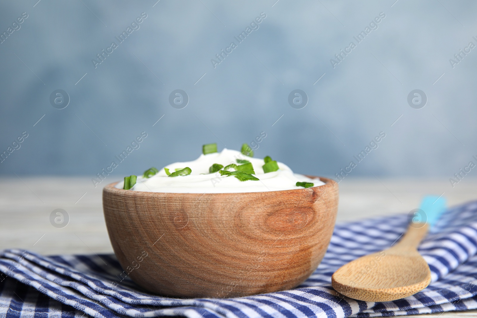 Photo of Fresh sour cream with onion on fabric