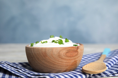Photo of Fresh sour cream with onion on fabric