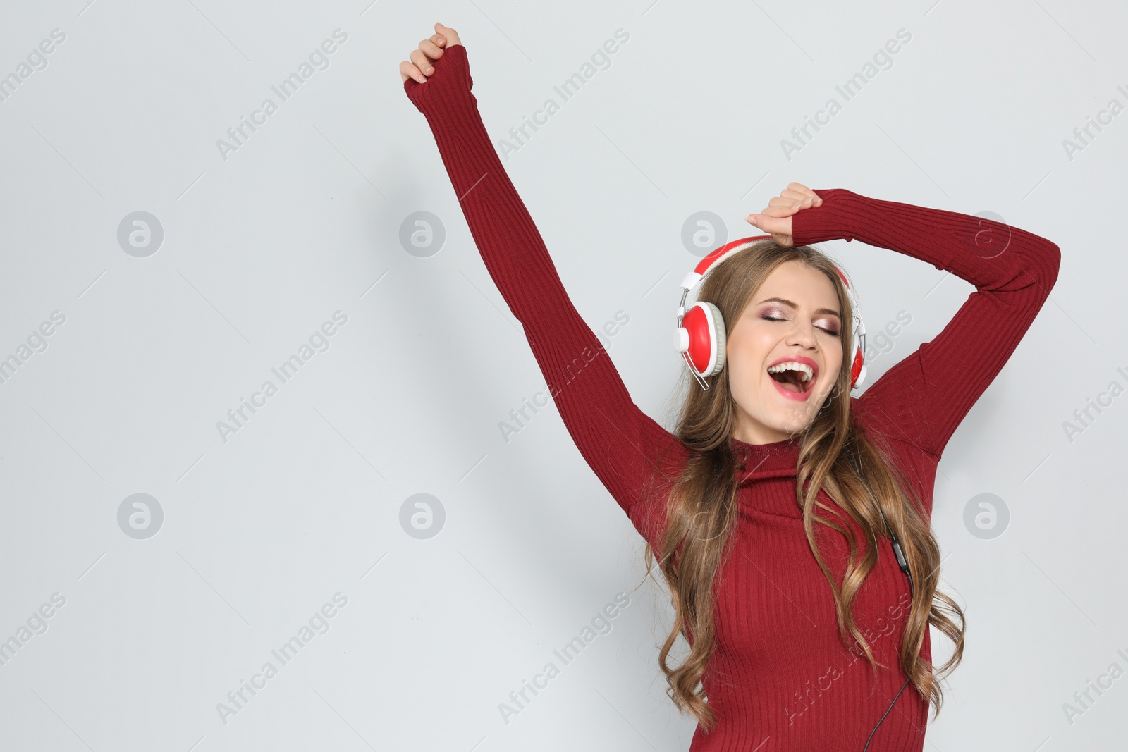 Photo of Young woman listening to Christmas music on color background