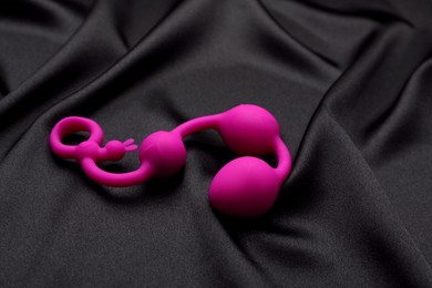Photo of Pink anal balls on black fabric. Sex toy